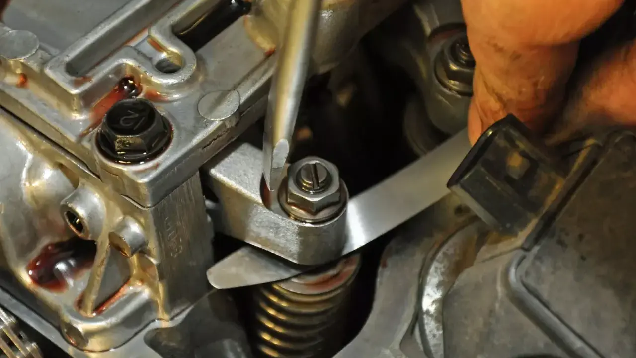 Mechanik reguluje luzy zaworowe, używając śrubokręta i szczelinomierza.