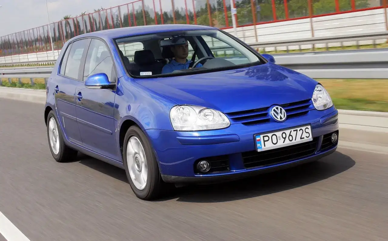 Niebieski Golf 5 1.9 TDI na drodze. Kierowca w niebieskiej koszulce prowadzi auto.