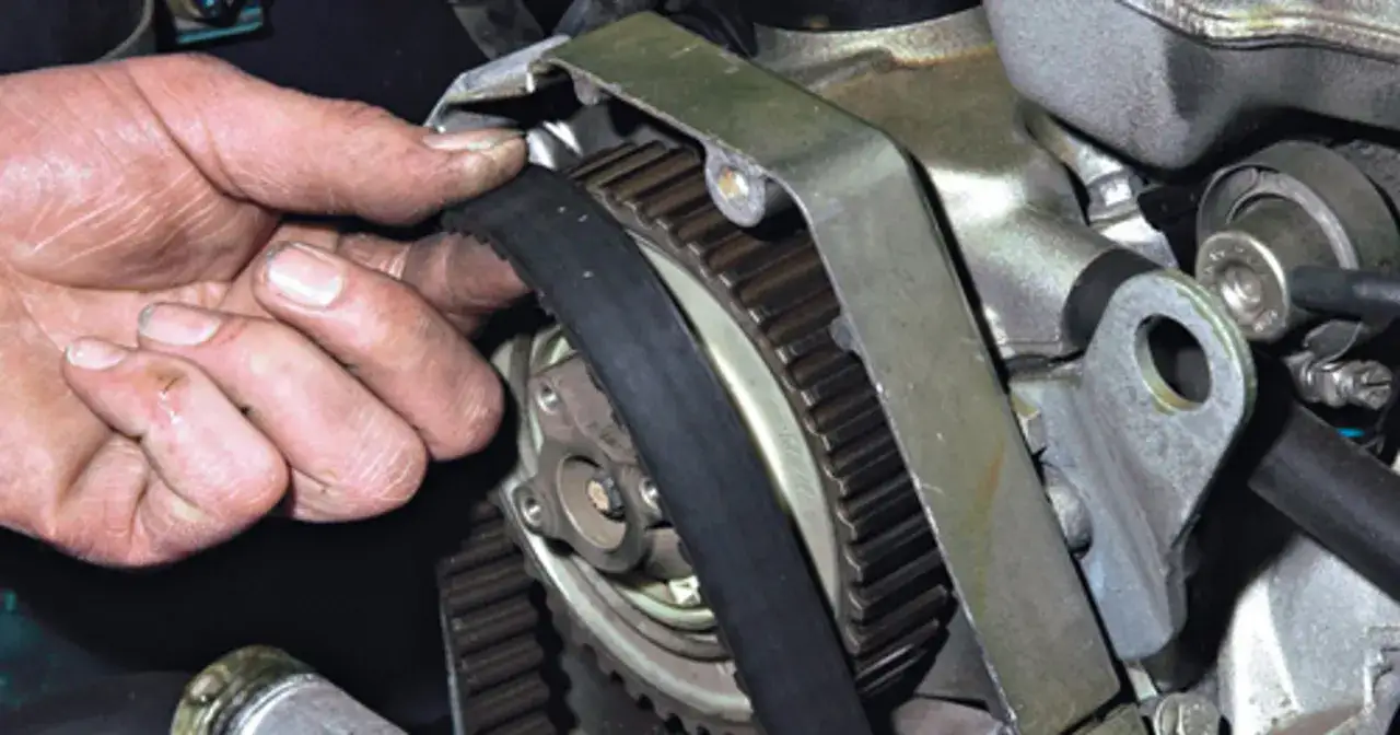 Dłoń mechanika reguluje pasek rozrządu. Bez niego silnik wydawałby niepokojący, metaliczny dźwięk.