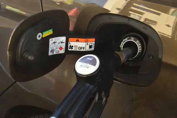 Dysza dystrybutora diesla wlewana do baku. Prosta instrukcja, jak zatankować auto, z oznaczeniami na klapce wlewu paliwa.